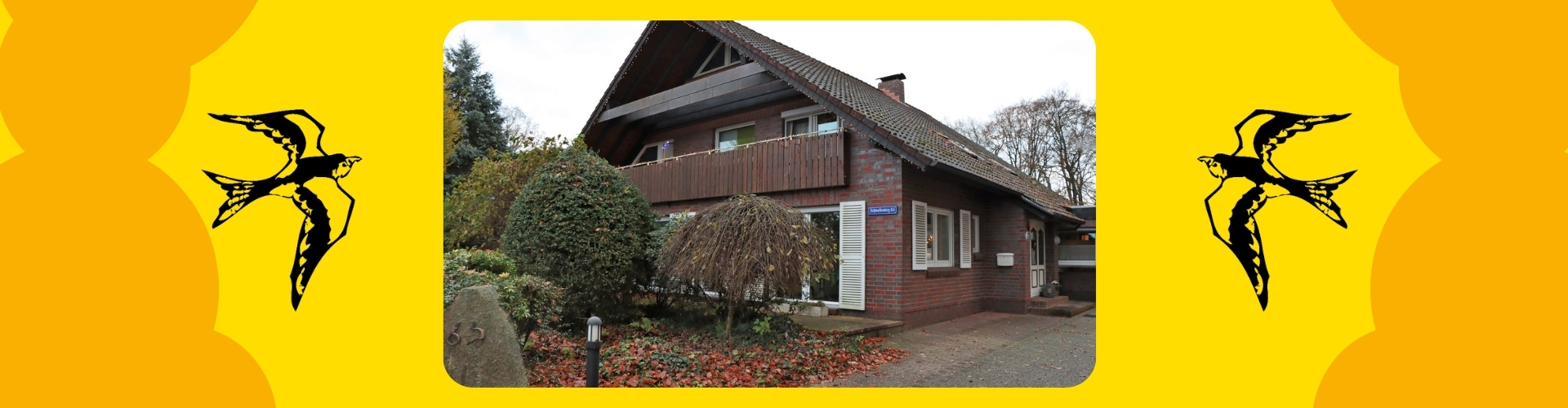 Das Wohngebäude "Die Schwalben" ist rot, hat ein Stockwerk mit Balkon, einen Dachboden und es einen Garten. Das Haus ist klein.