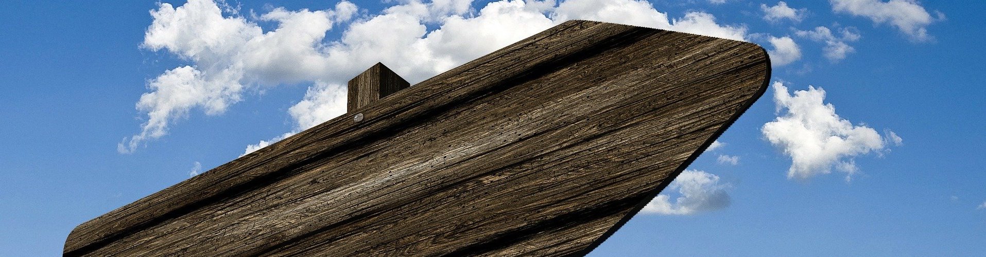 Ein Holzschild draußen mit Himmel