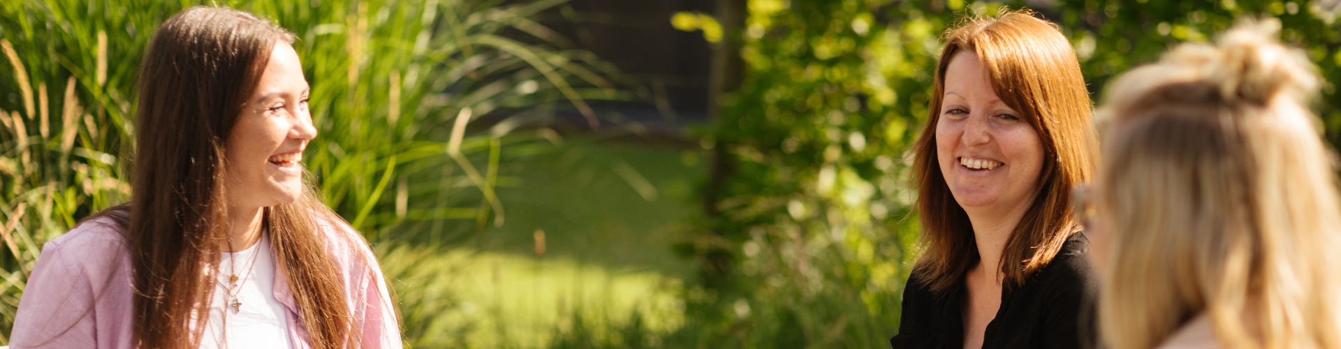 Drei GPS Mitarbeiterinnen sind draußen im Garten bei der GPS Verwaltung.