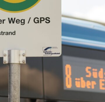 Ein Bus hält an einer Bushaltestelle bei der GPS Verwaltung.