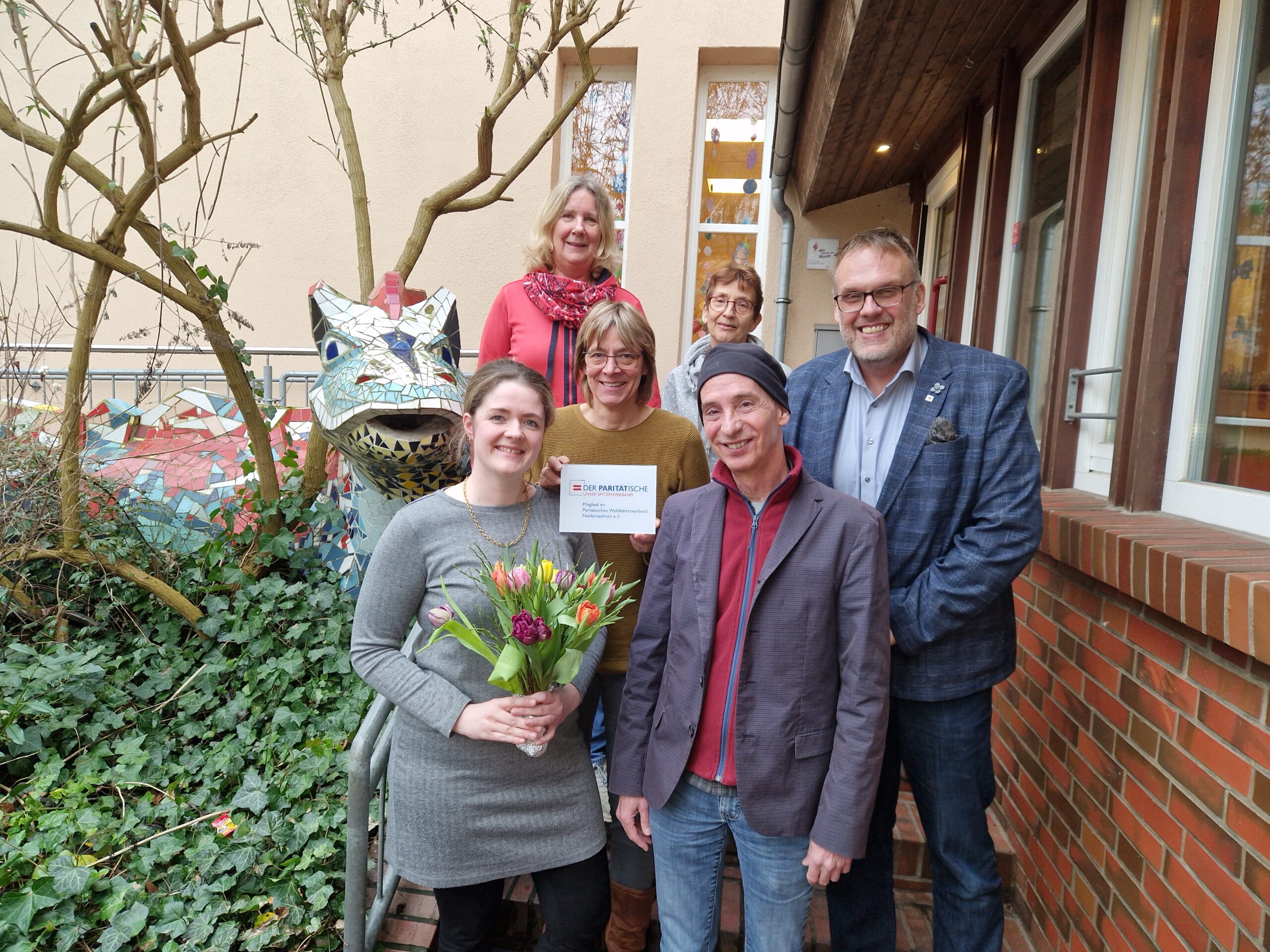 Der Geschäftsführer der GPS Klaus Puschmann und GPS Mitarbeiterinnen. Eine junge Frau hat als Geschenk Blumen bekommen.