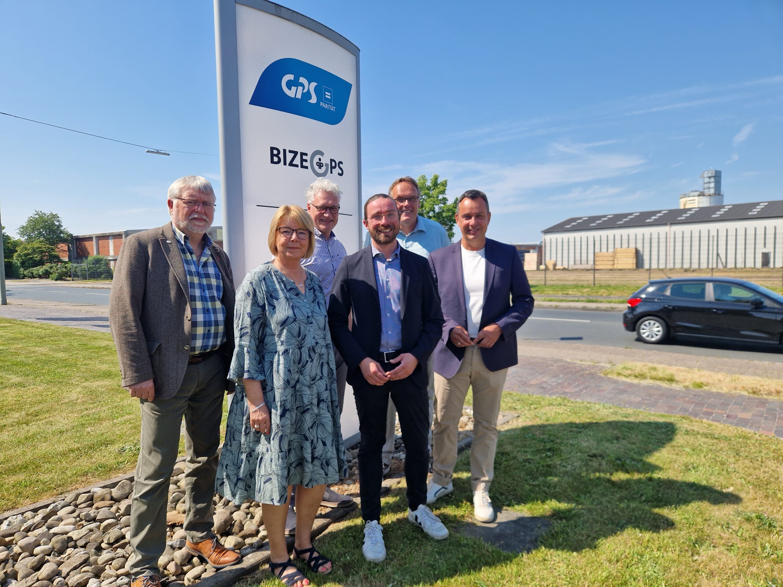 Man sieht auf dem Bild GPS Mitarbeiter und der Geschäftsführer der GPS zusammen mit einem Politiker auf dem Foto vor dem Bizeps Gebäude draußen bei schönen sonnigen Wetter.