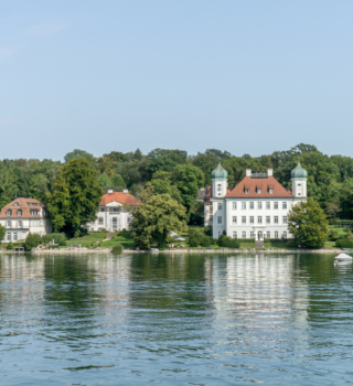 Eine Burg und Häuser. Auf dem Bild sieht man auch einen See.