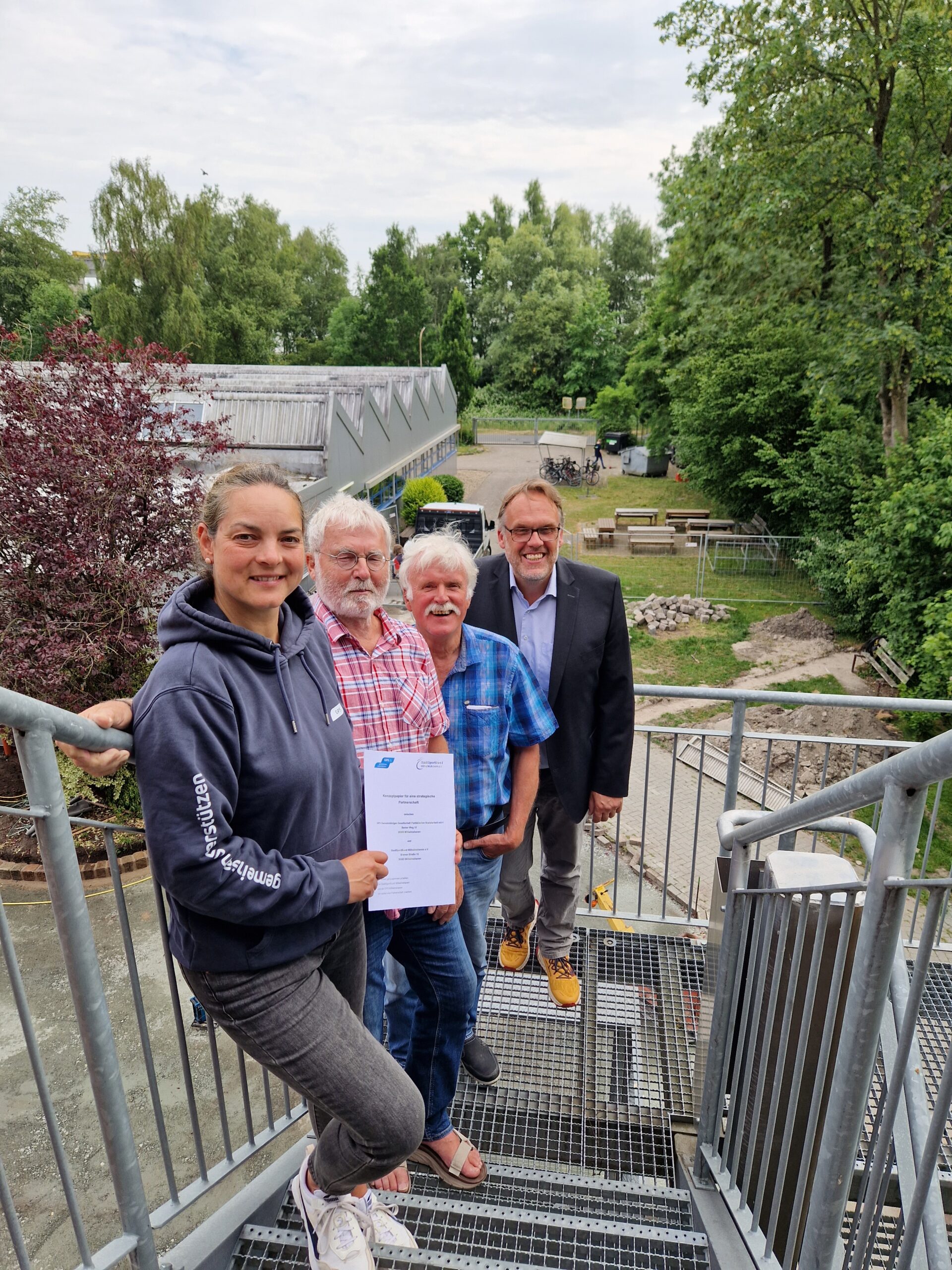 Draußen bei der Werkstatt Wilhelmshaven auf den Notfalltreppen mit dem Geschäftsführer der GPS Klaus Puschmann, Leiterin vom GPS Sport & Freizeit Kati Kross mit zwei älteren Männern.