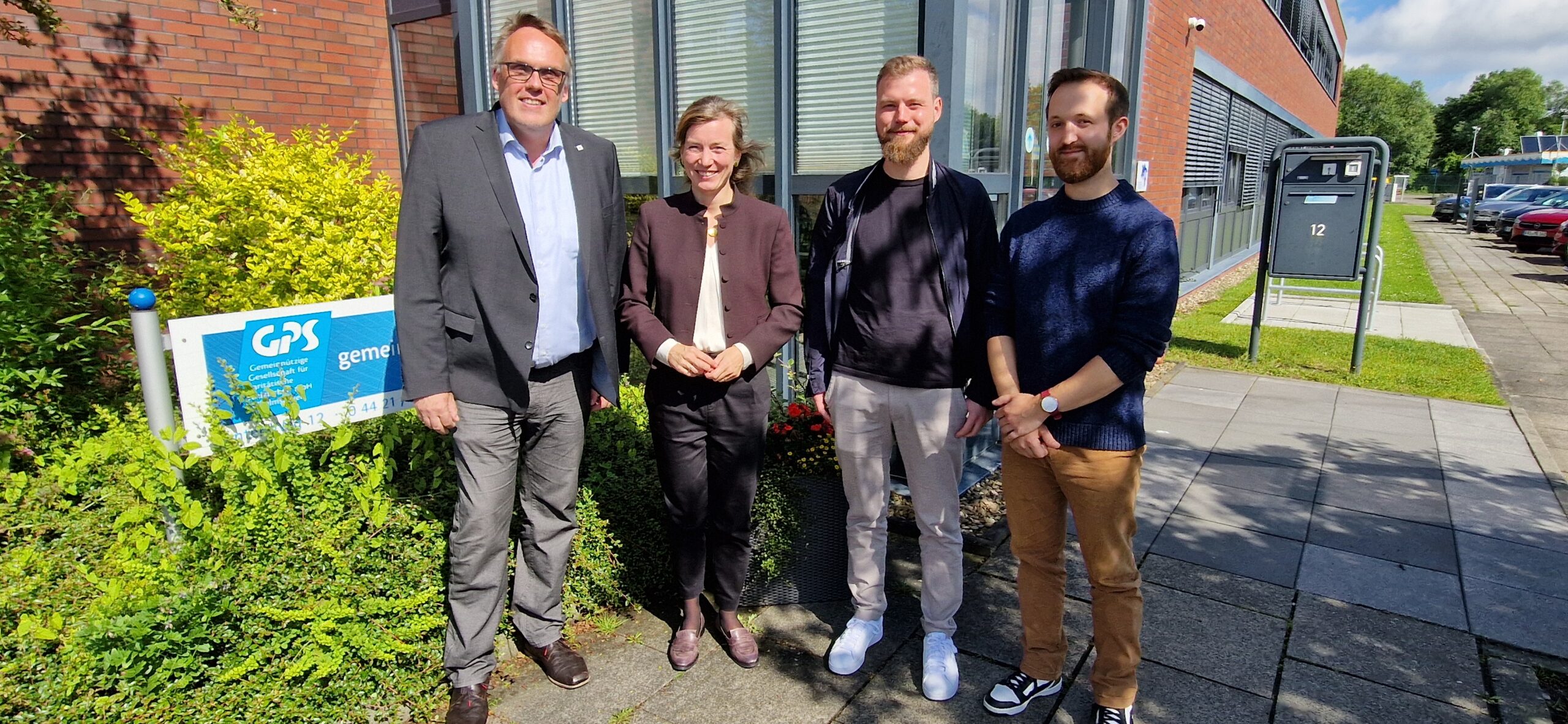 Gruppenfoto vor der GPS Verwaltung mit dem Geschäftsführer der GPS, zwei GPS Mitarbeiter und die Politikerin Siemtje Möller