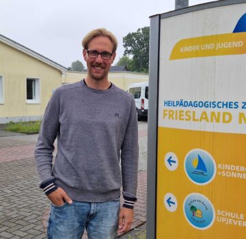 Ein Foto draußen auf dem Gelände des Heilpädagogischen Zentrums Friesland Nord mit dem Leiter des Zentrums.