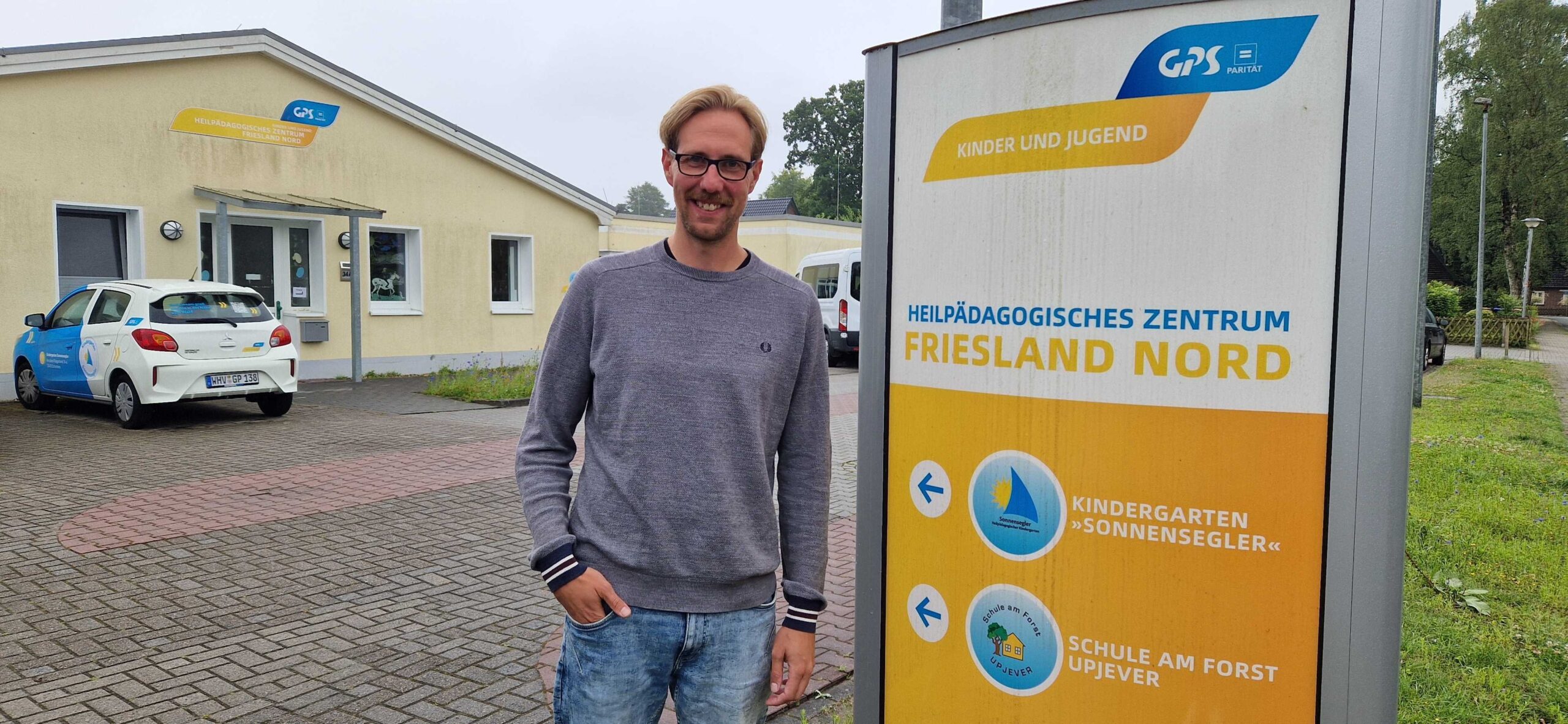 Ein Foto draußen auf dem Gelände des Heilpädagogischen Zentrums Friesland Nord mit dem Leiter des Zentrums.