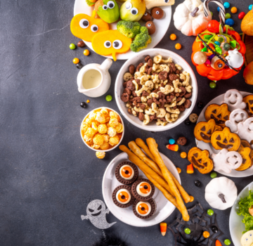 Viele Süßigkeiten und Snacks auf einem schwarzen Tisch bei einer Halloweens Feier im Treffpunkt Teilhabe.