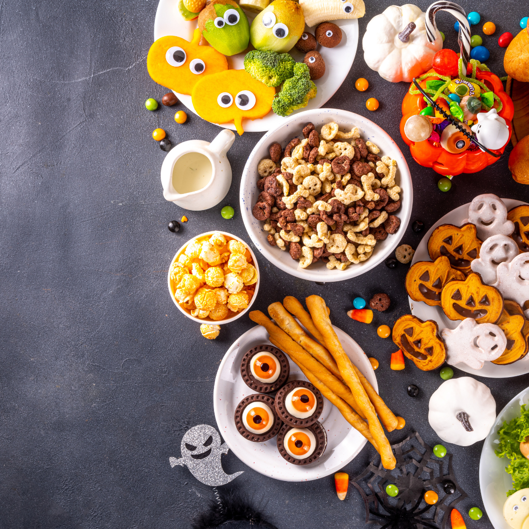 Viele Süßigkeiten und Snacks auf einem schwarzen Tisch bei einer Halloweens Feier im Treffpunkt Teilhabe.