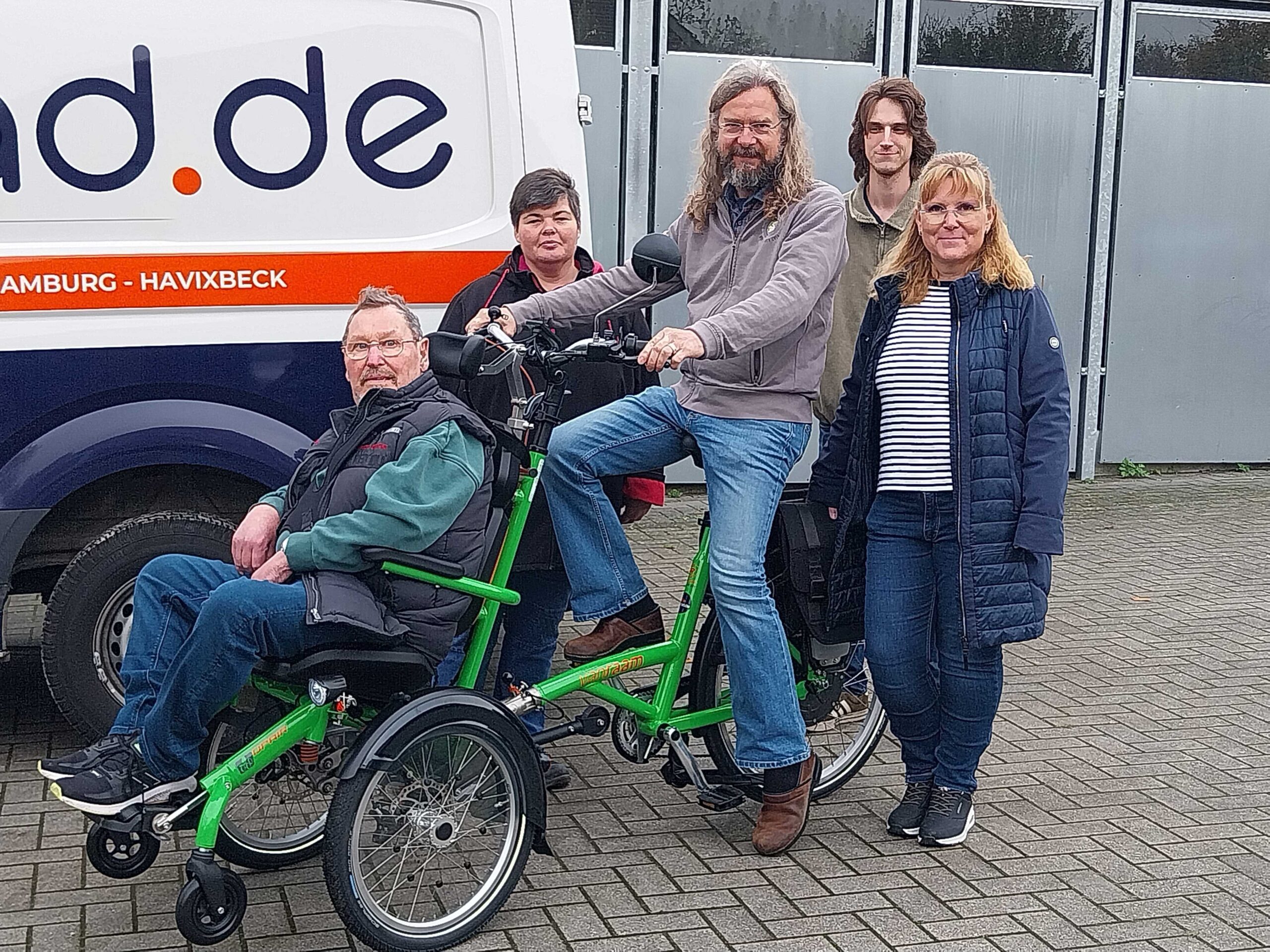 Ein GPS Mitarbeiter namens Kay Engel und vier andere Menschen präsentieren ein inklusives Fahrrad.