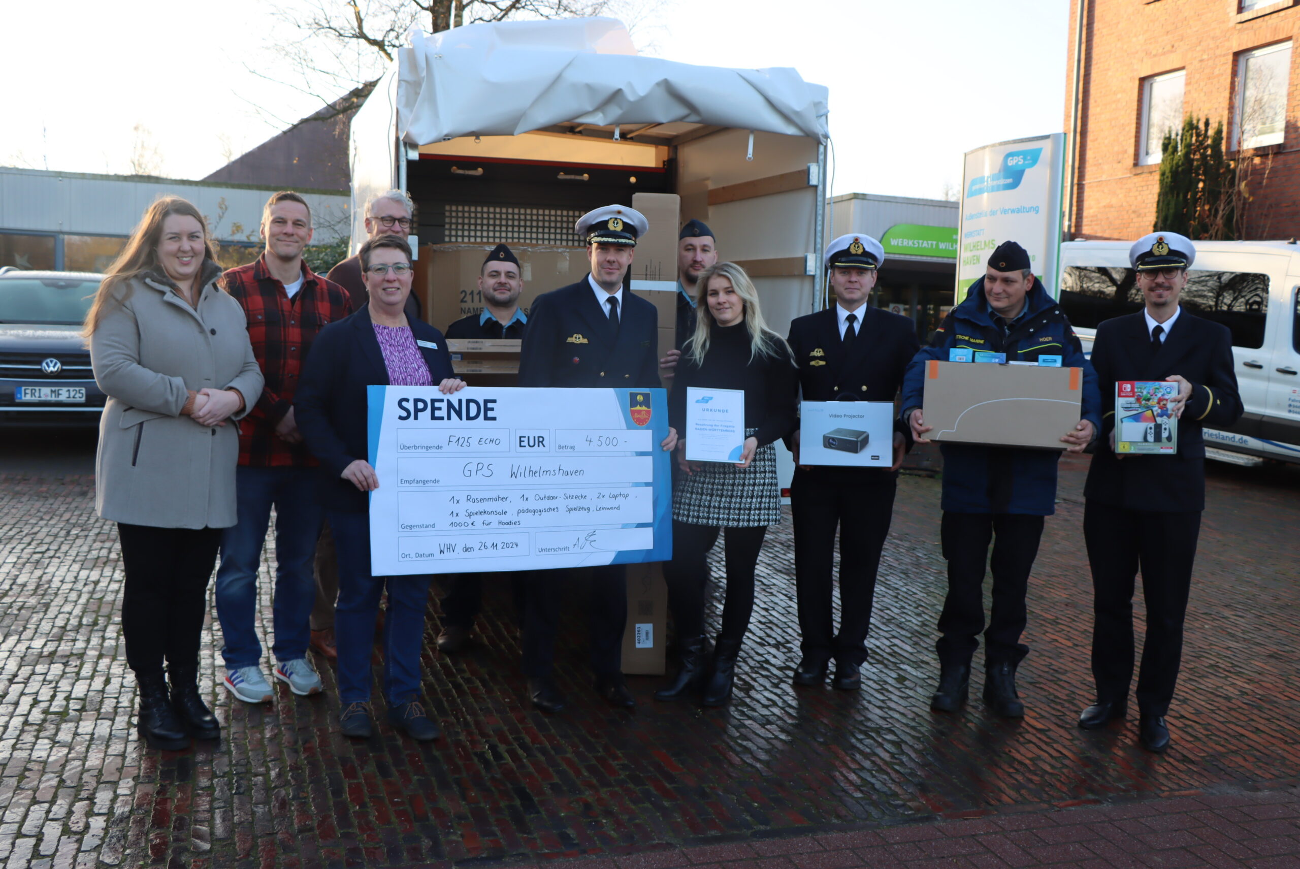 Spendenübergabe Bundeswehr Echo 125 draußen vor der Werkstatt Wilhelmshaven. Es scheint die Sonne.