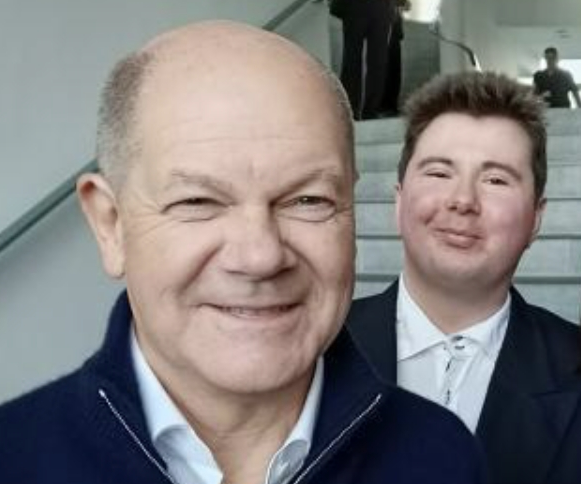 Der Bundeskanzler von der Bundesrepublik Deutschland und ein junger Politiker vor der Kamera.