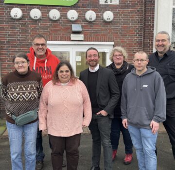 Gruppenfoto draußen mit dem Geschäftsführer der GPS, ein junger Politiker, eine GPS-Mitarbeiterin, der Leiter der GPS Werkstatt ARTEC Roffhausen und drei Beschäftigte der Werkstatt.