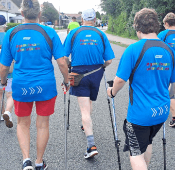 Eine Sportgruppe von Menschen beim Walken auf der Straße.