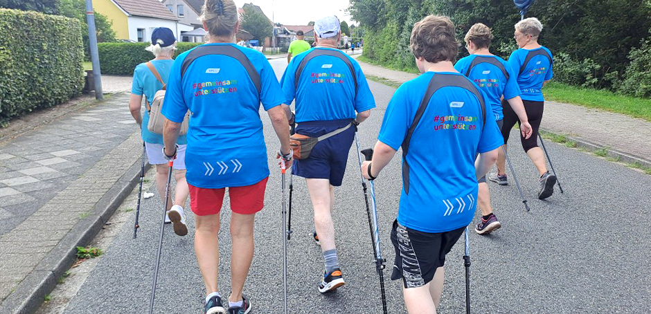 Eine Sportgruppe von Menschen beim Walken auf der Straße.