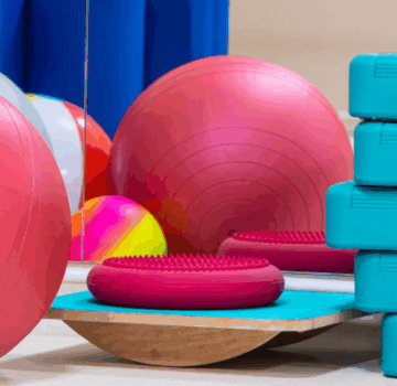 Viele Sportgeräte wie zum Beispiel viele Gymnastikbälle, Hanteln und Stepper.