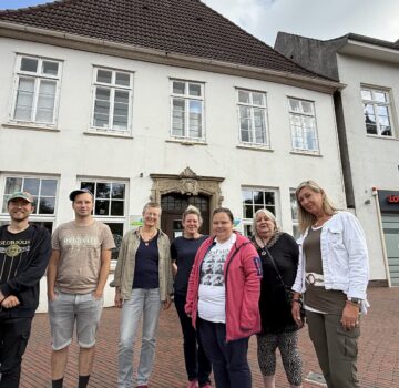 Ein Gruppenfoto mit Männer und Frauen draußen vor der Tagesstätte Schlosskäserei in Jever.