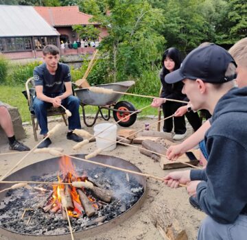 FSJ'ler beim Grillen von Marshmallows draußen an einem Grillplatz.