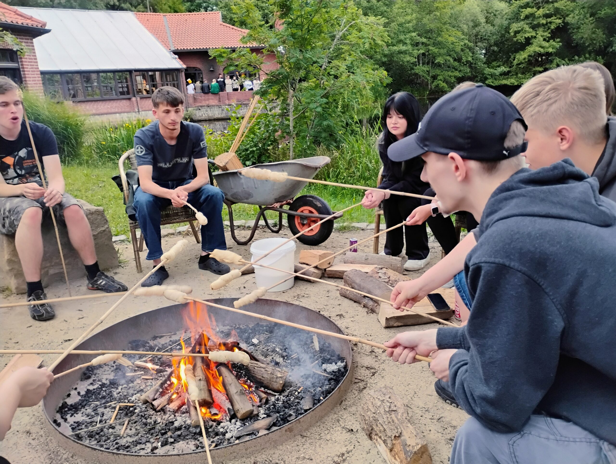 FSJ'ler beim Grillen von Marshmallows draußen an einem Grillplatz.