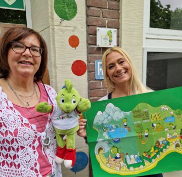 Zwei GPS Mitarbeiterinnen präsentieren eine Stoffpuppe und ein Kinderspiel aus Papier.