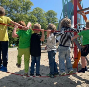 Kinder auf einem Spielplatz. Die Sonne scheint.