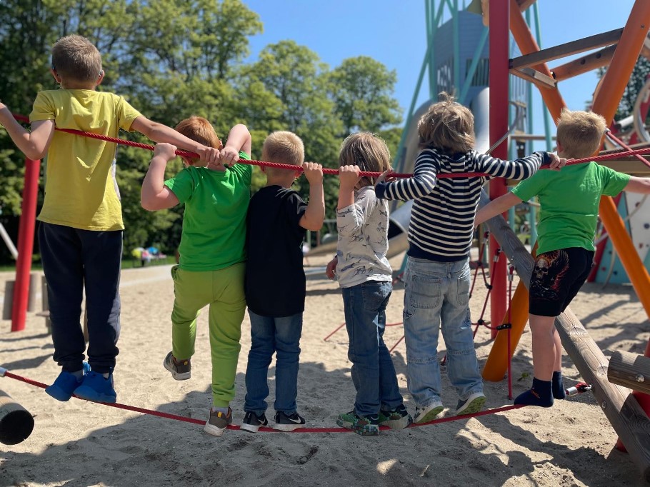 Kinder auf einem Spielplatz. Die Sonne scheint.