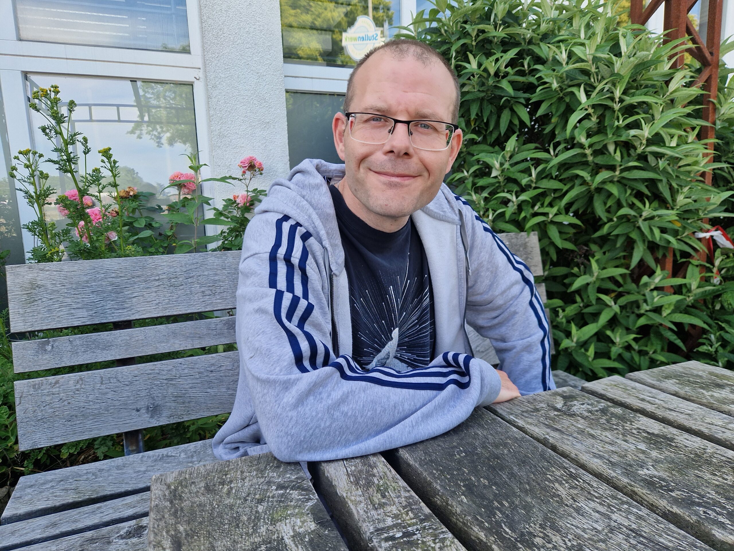 Ein GPS Beschäftigter namens Massimo Marongiu. Er sitzt draußen im Garten der GPS Werkstatt "ARTEC Roffhausen".