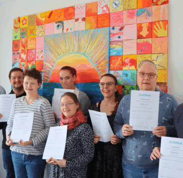 Gruppenfoto von acht GPS Beschäftigten, die ihre Ausbildung als Alltagshelfer im Jahr 2025 abgeschlossen haben.