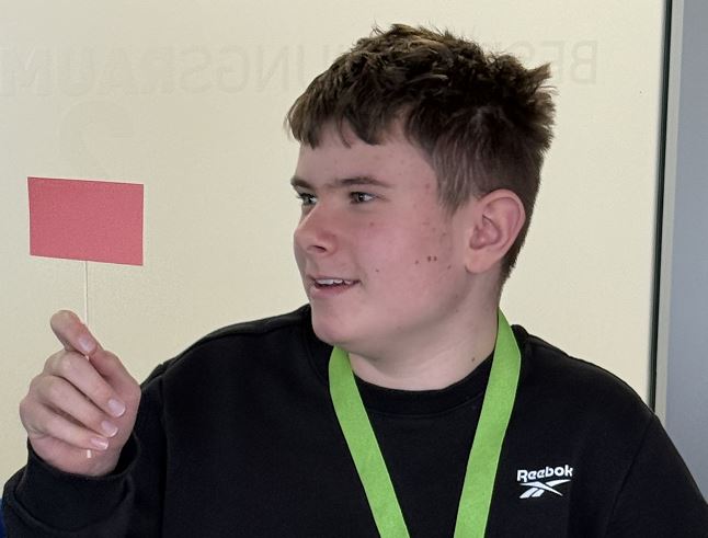 Ein Schüler mit Namensschild um den Hals